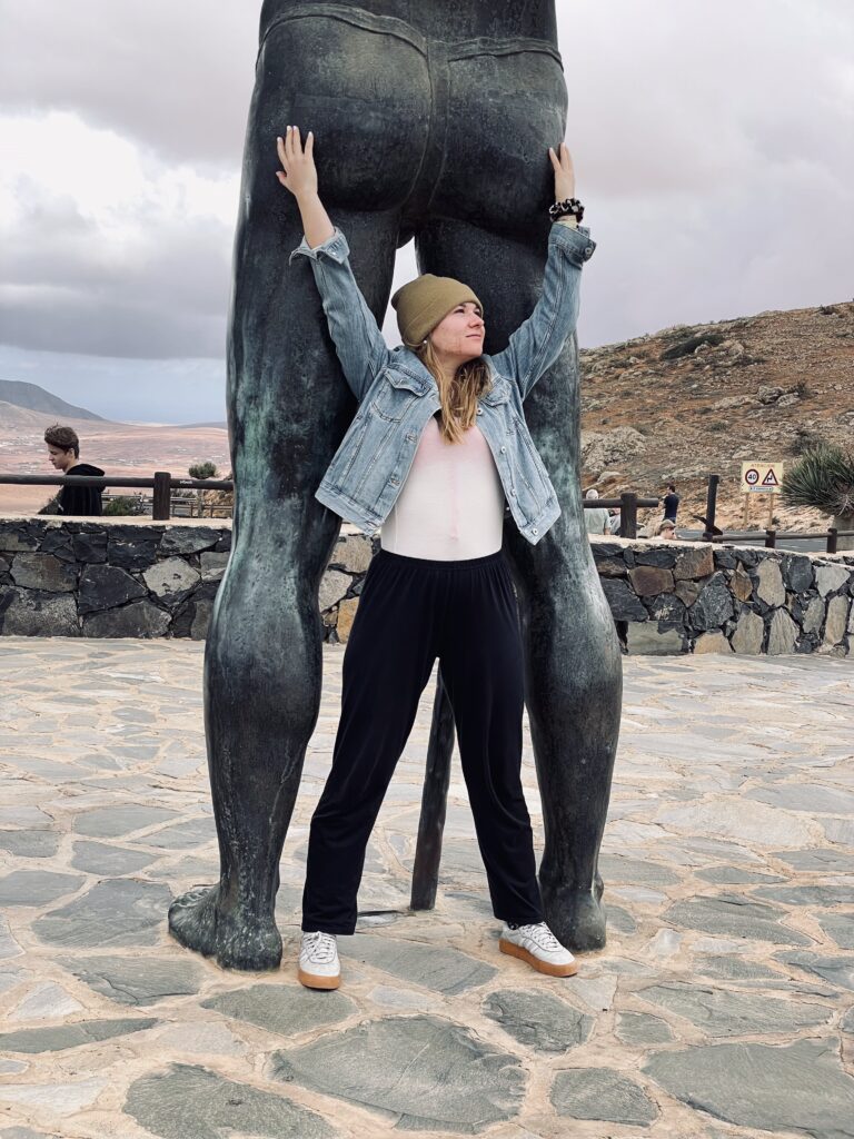 Ida posiert an den Hinterbeinen einer Statue indem sie die Handoberflächen auf die Pobacken der Statue streckt